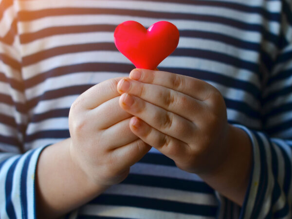 Les mains d'un enfant qui tient un cœur