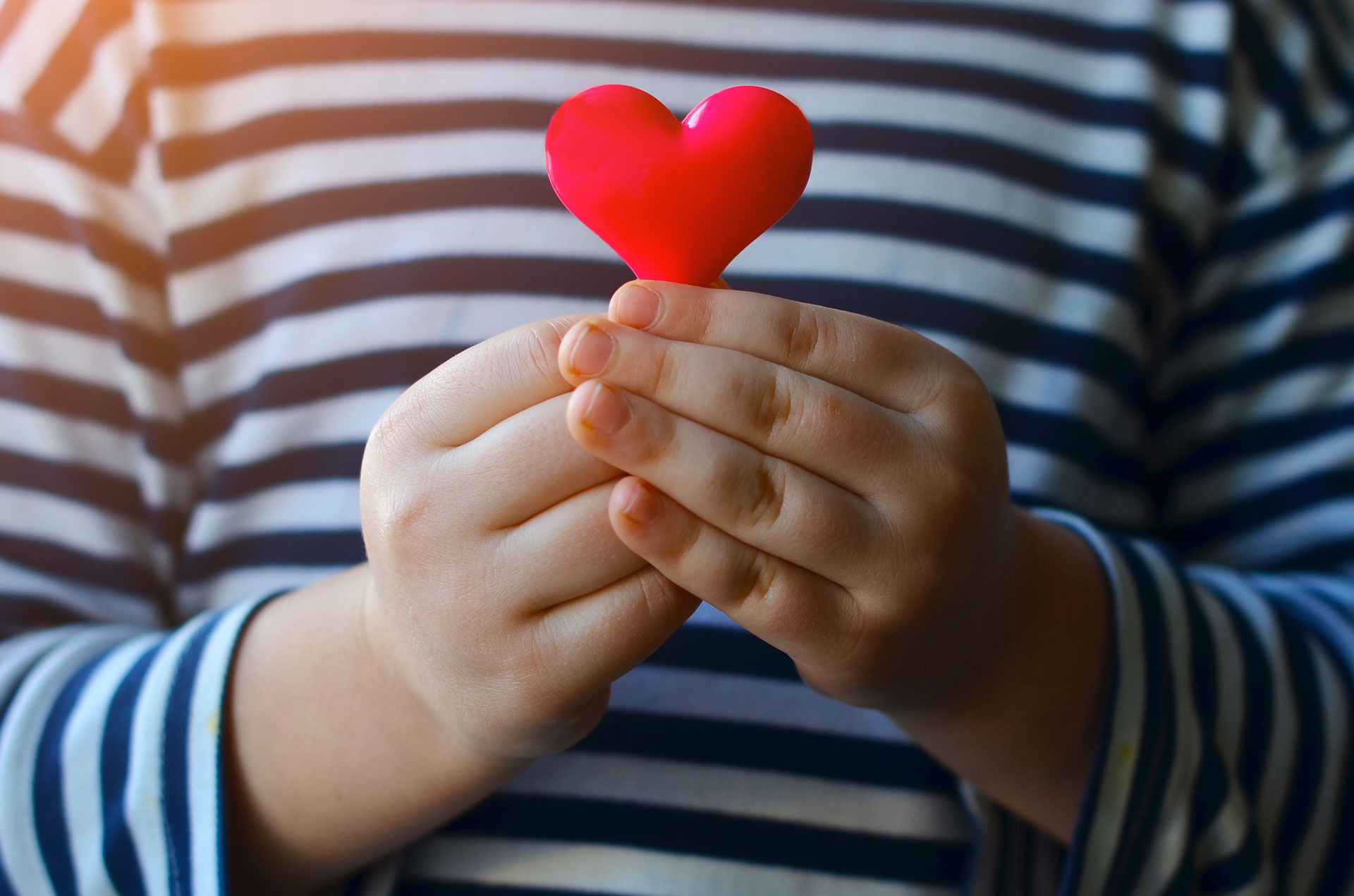 Les mains d'un enfant qui tient un cœur