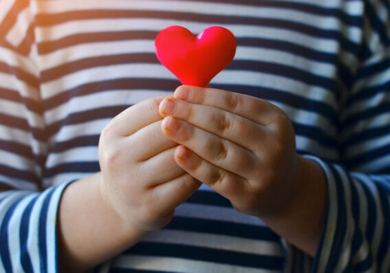 Les mains d'un enfant qui tient un cœur